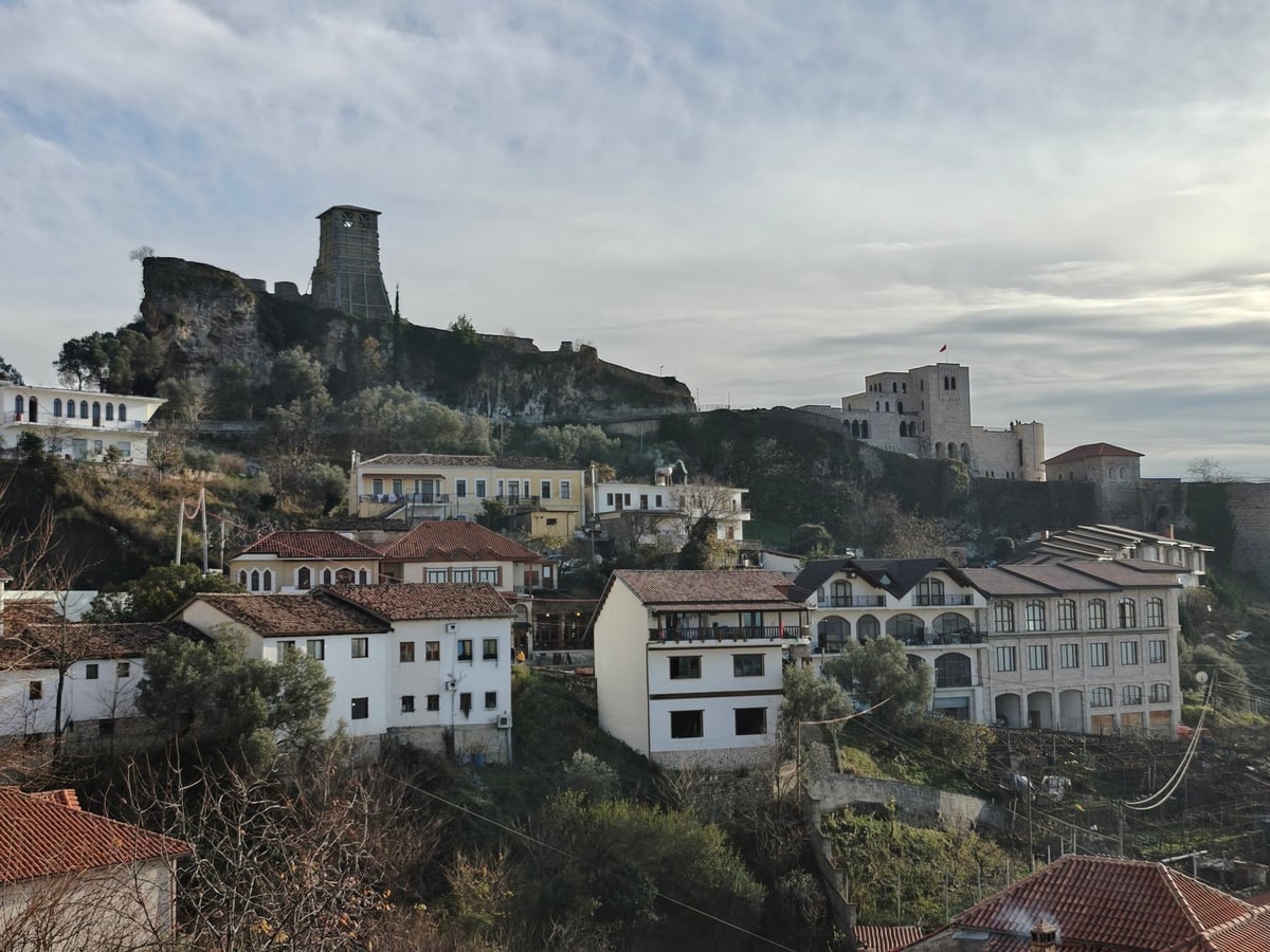 Vista de Gjirokastër con sus casas tradicionales y el castillo en la colina.