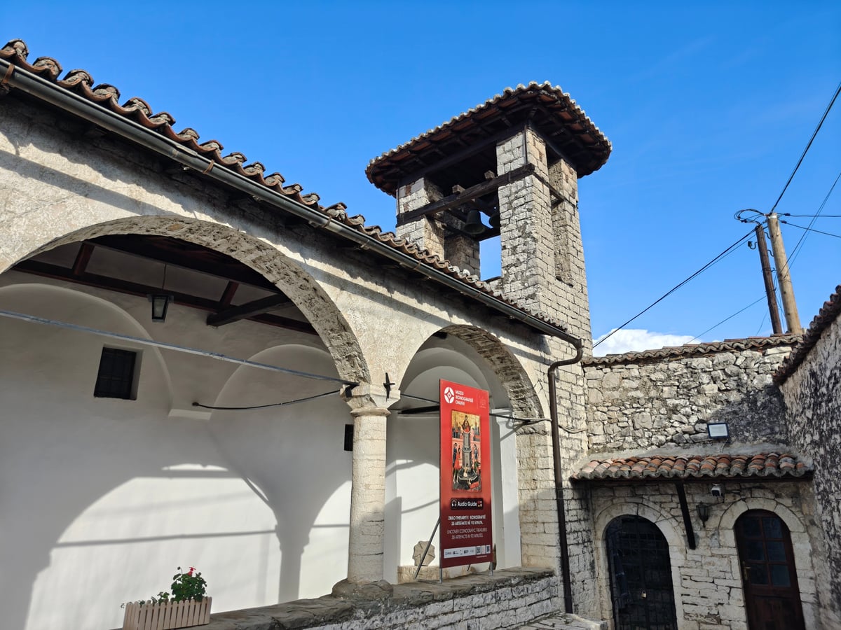 Edificio histórico de piedra con patio y torre de estilo tradicional en Berat.