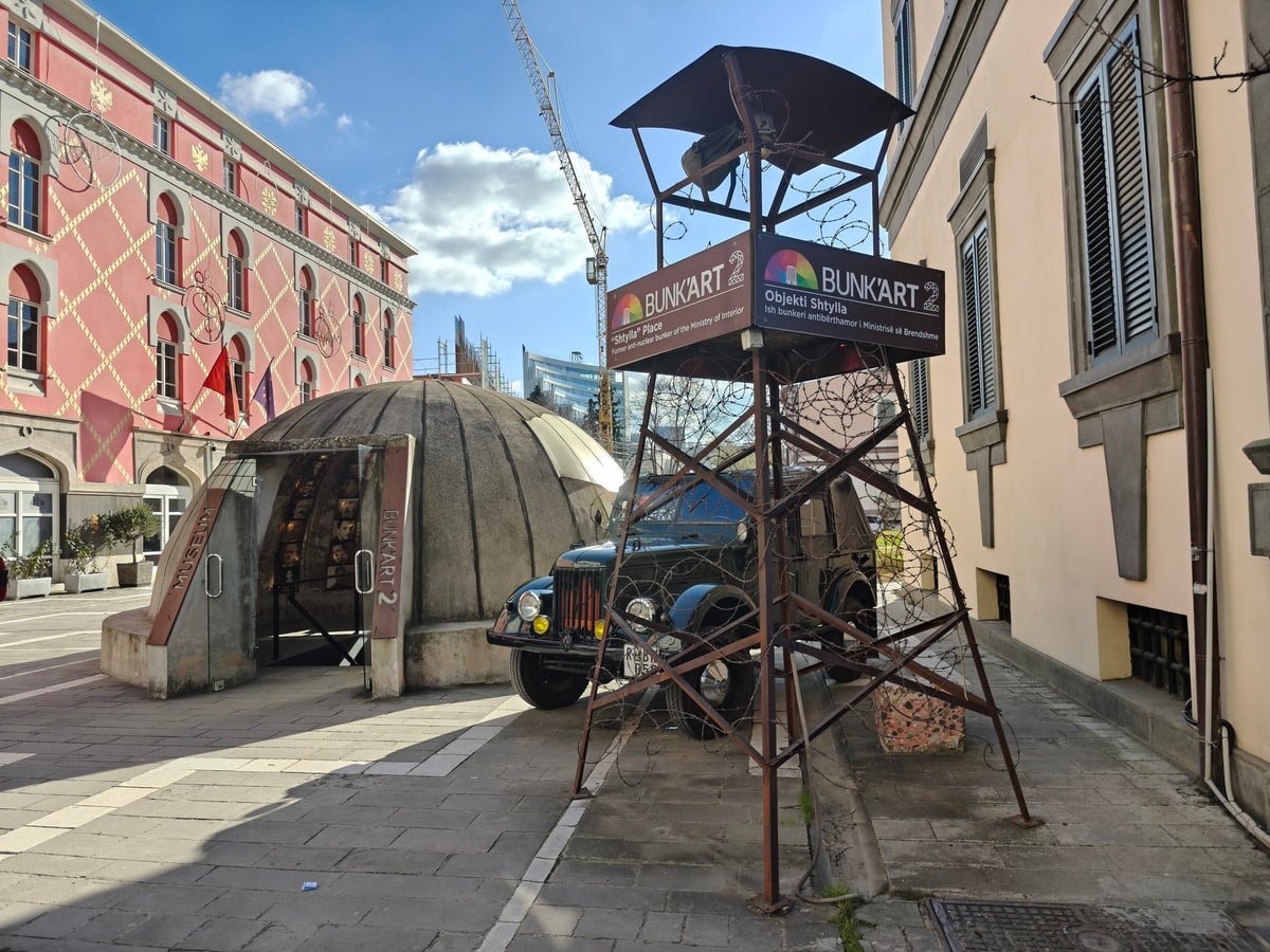La entrada al búnker museo Bunk'Art 2 en Tirana, con su puerta blindada semienterrada bajo un jardín urbano.