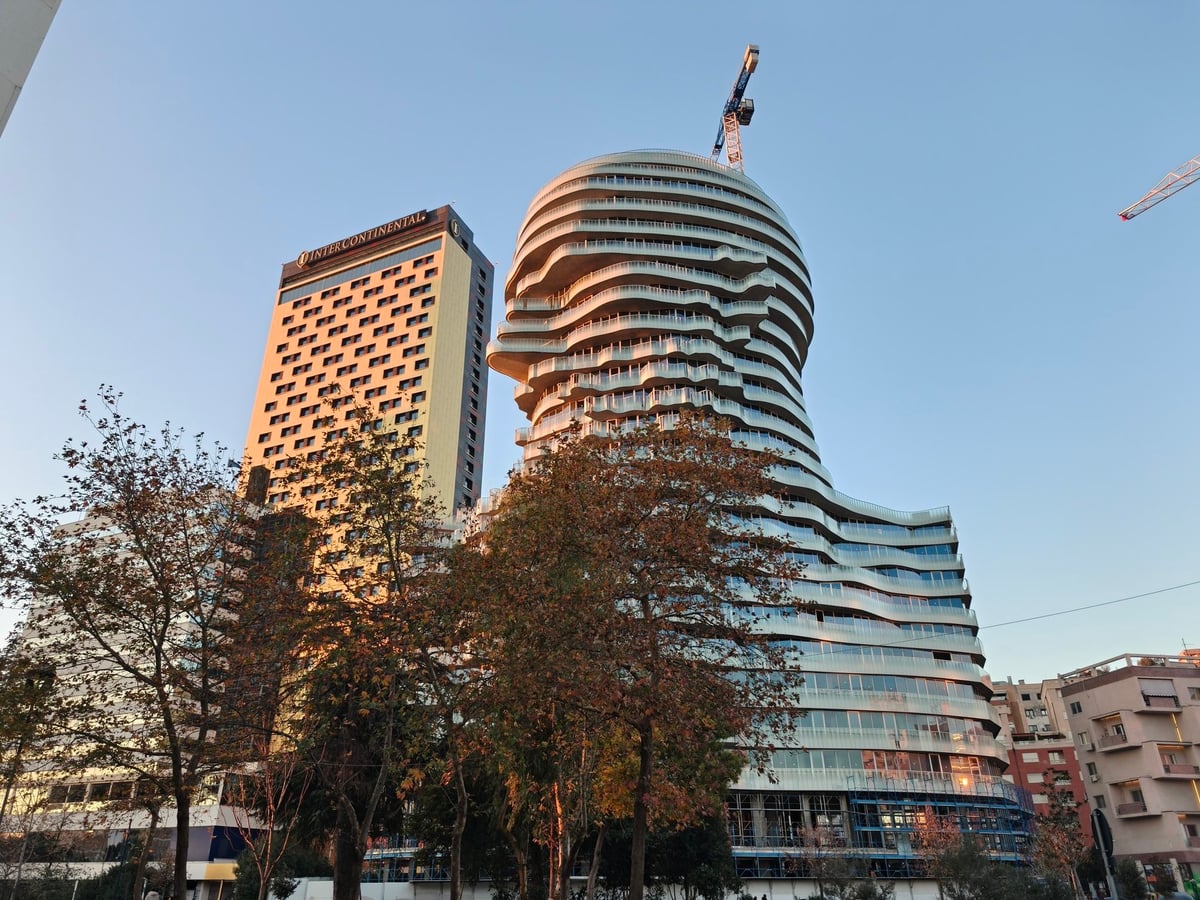 Edificio moderno de formas curvas entre los edificios del centro de Tirana.
