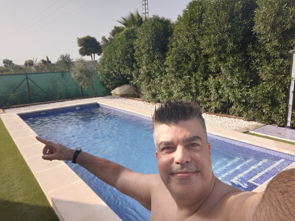 Persona junto a una piscina de una casa