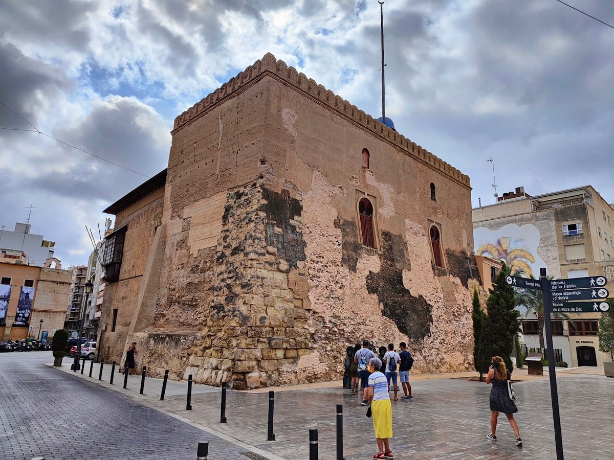 Edificio histórico de piedra en una plaza.