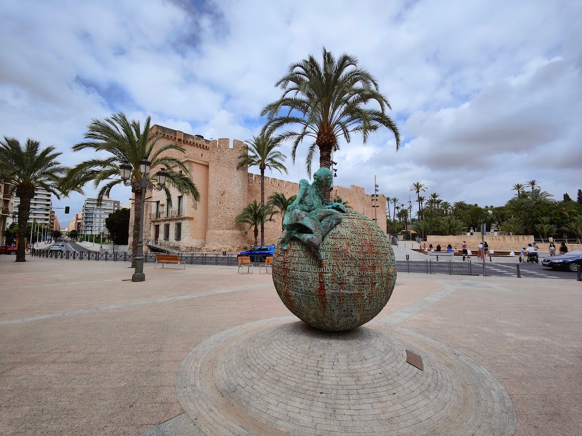 Plaza con una gran escultura decorativa y palmeras