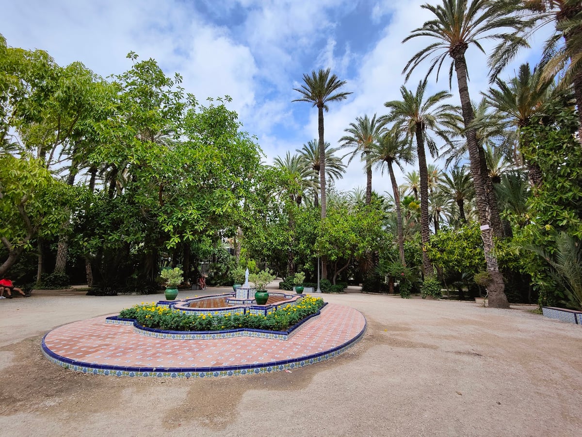 Jardín con fuente rodeada de vegetación