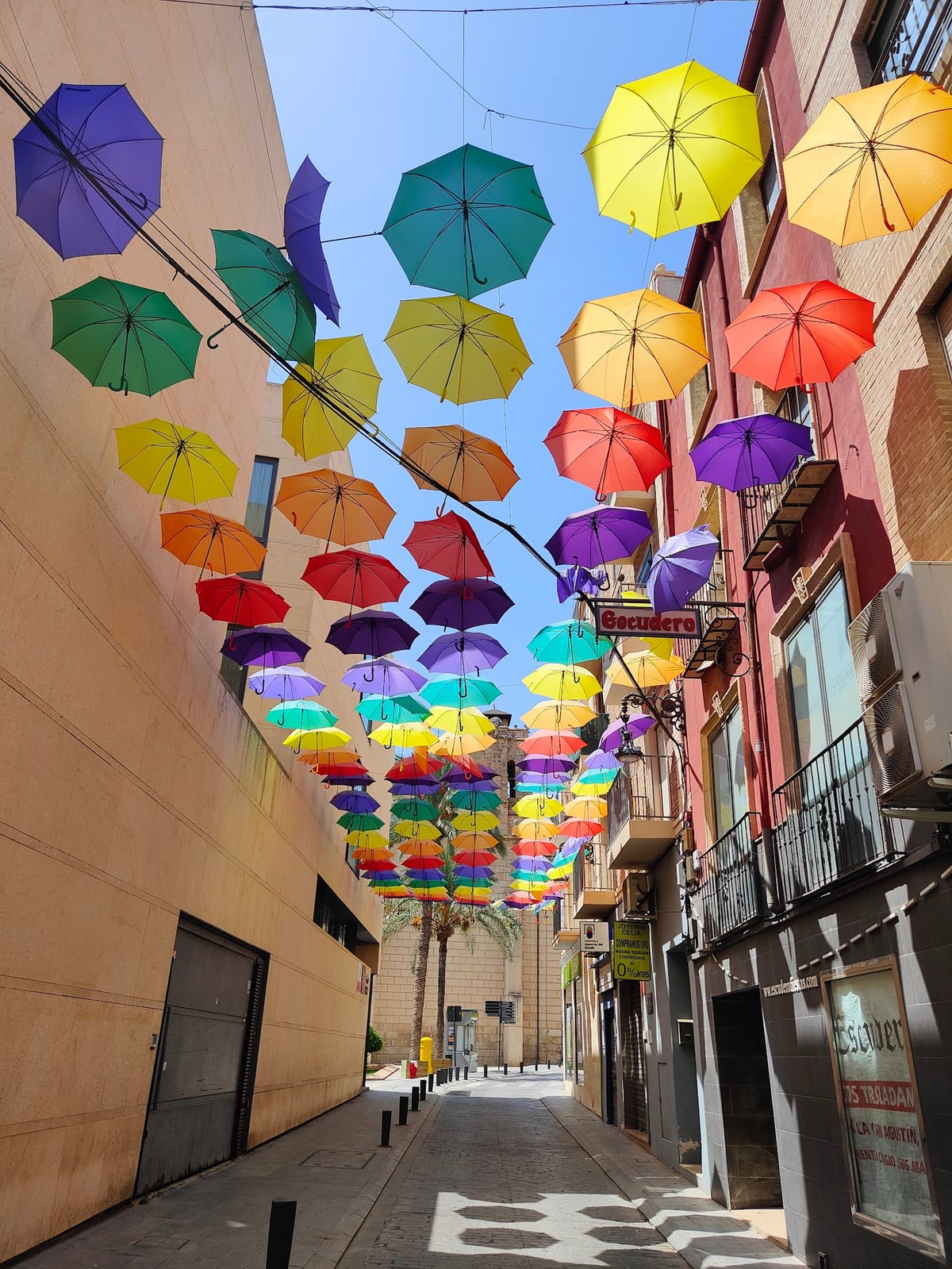 Calle peatonal decorada con paraguas de colores