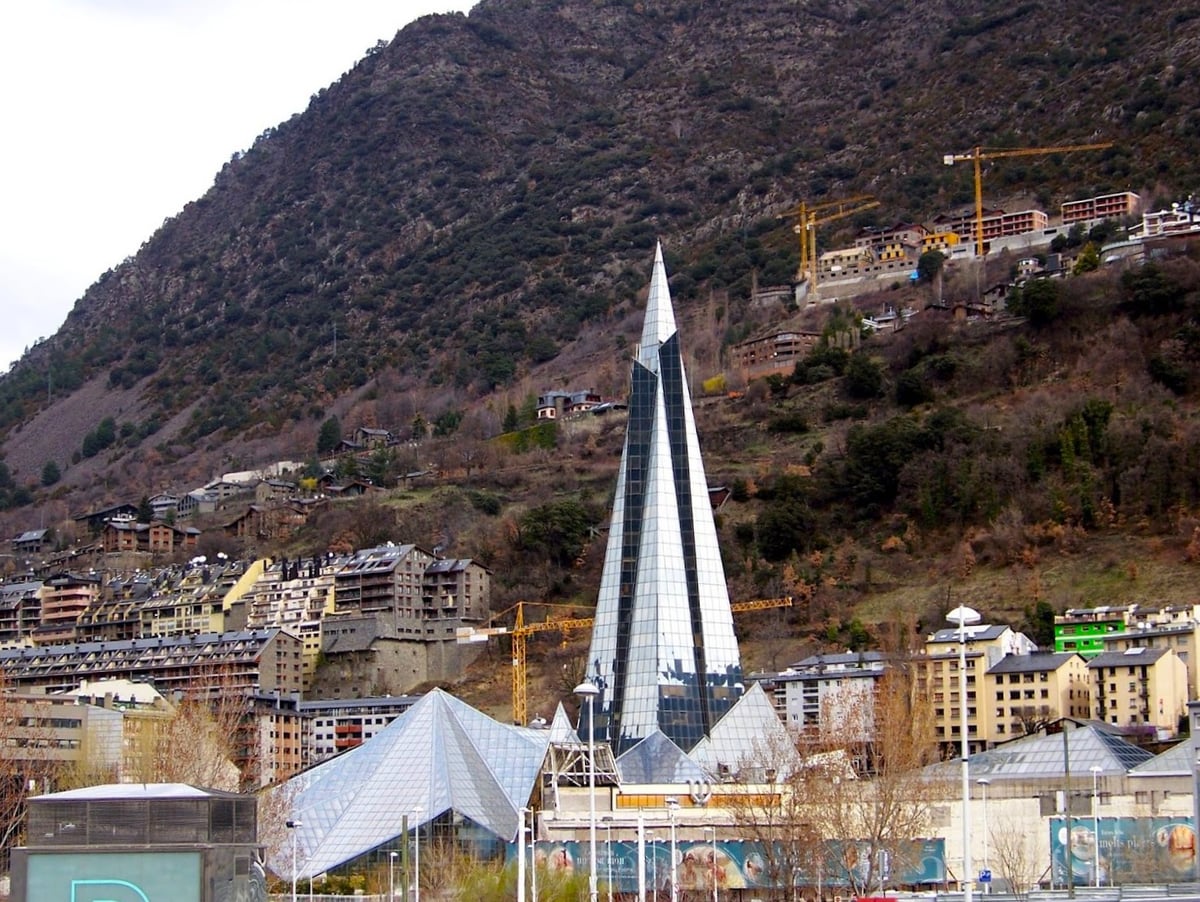 El edificio moderno de Caldea, con su pirámide de cristal, y la montaña al fondo en el centro de Andorra.