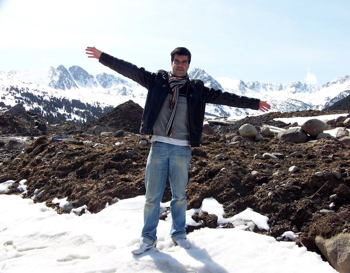 Una persona contemplando un paisaje alpino nevado en las montañas de Andorra.