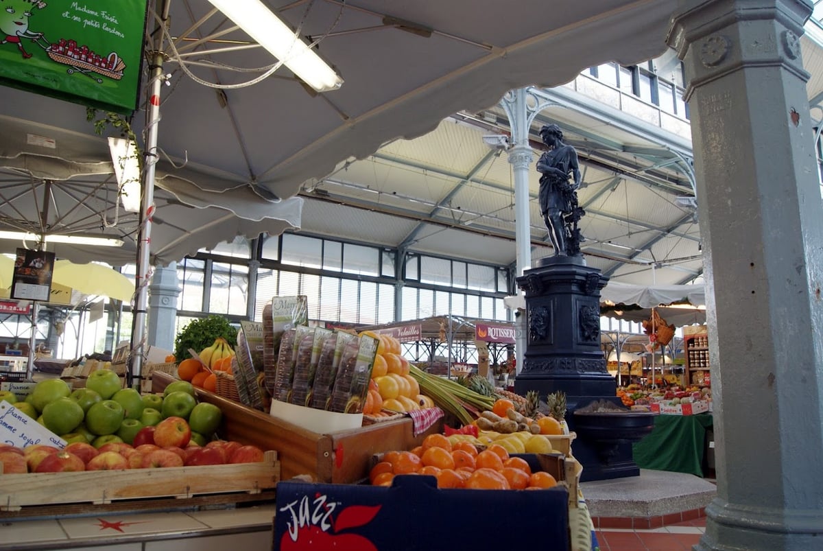 Mercado cubierto con puestos de frutas y verduras