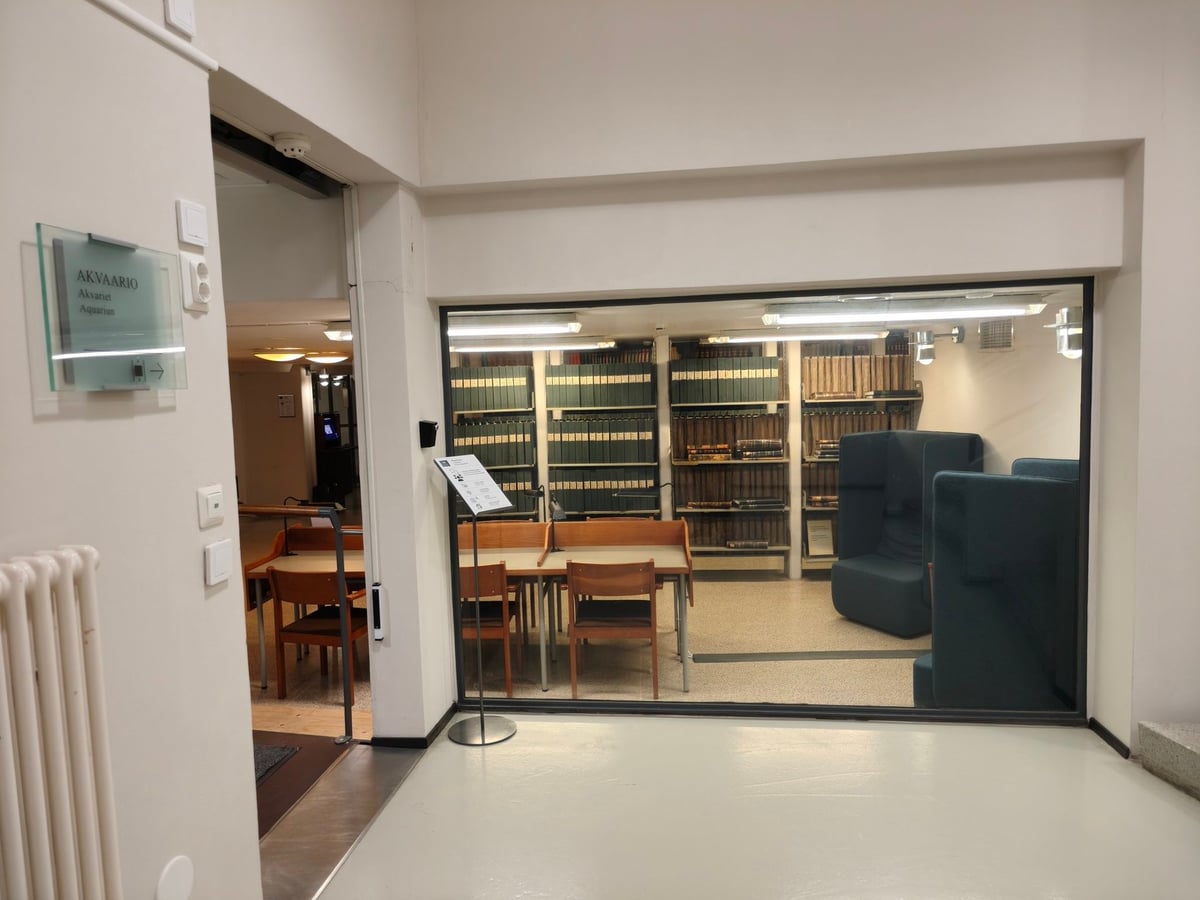 Sala de estudio con paredes de cristal y el cartel Akvaario junto a la entrada