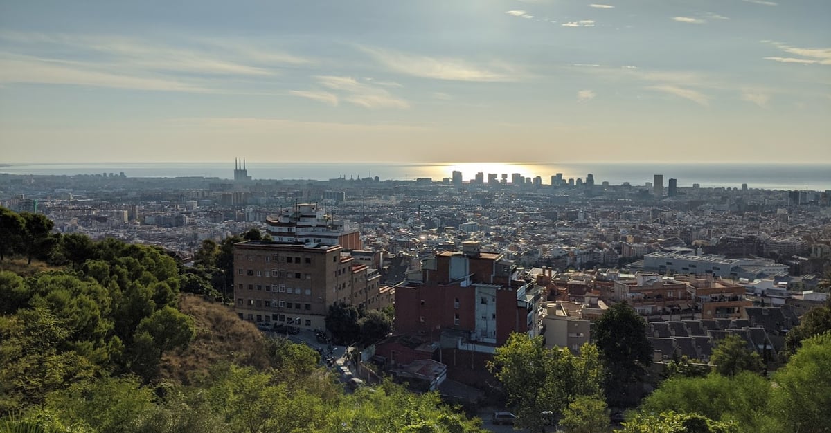 Barcelona vista desde los Bunkers del Carmel al atardecer, con la Sagrada Família recortada junto al mar al fondo