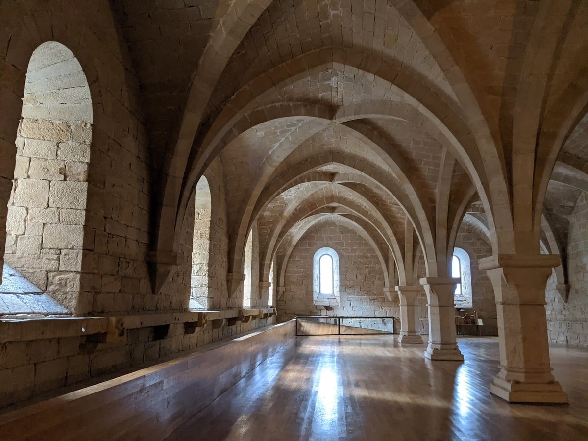 Galería abovedada de piedra iluminada por ventanas