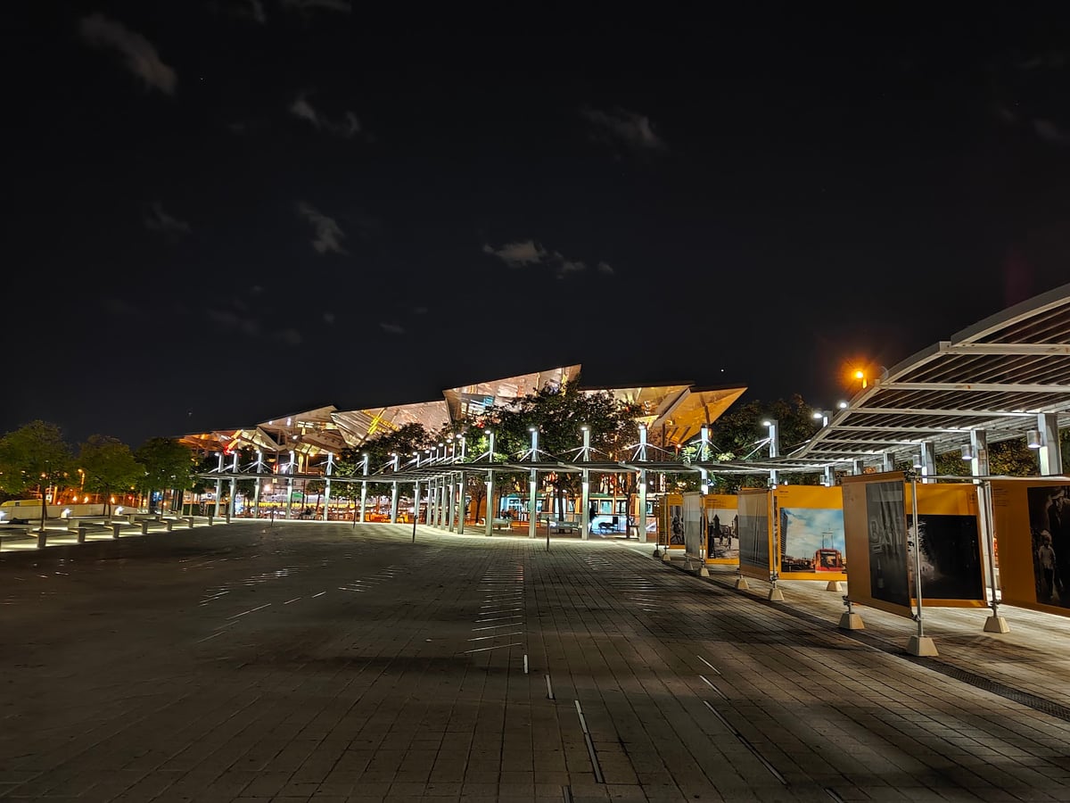 Paseo urbano iluminado junto a edificios modernos