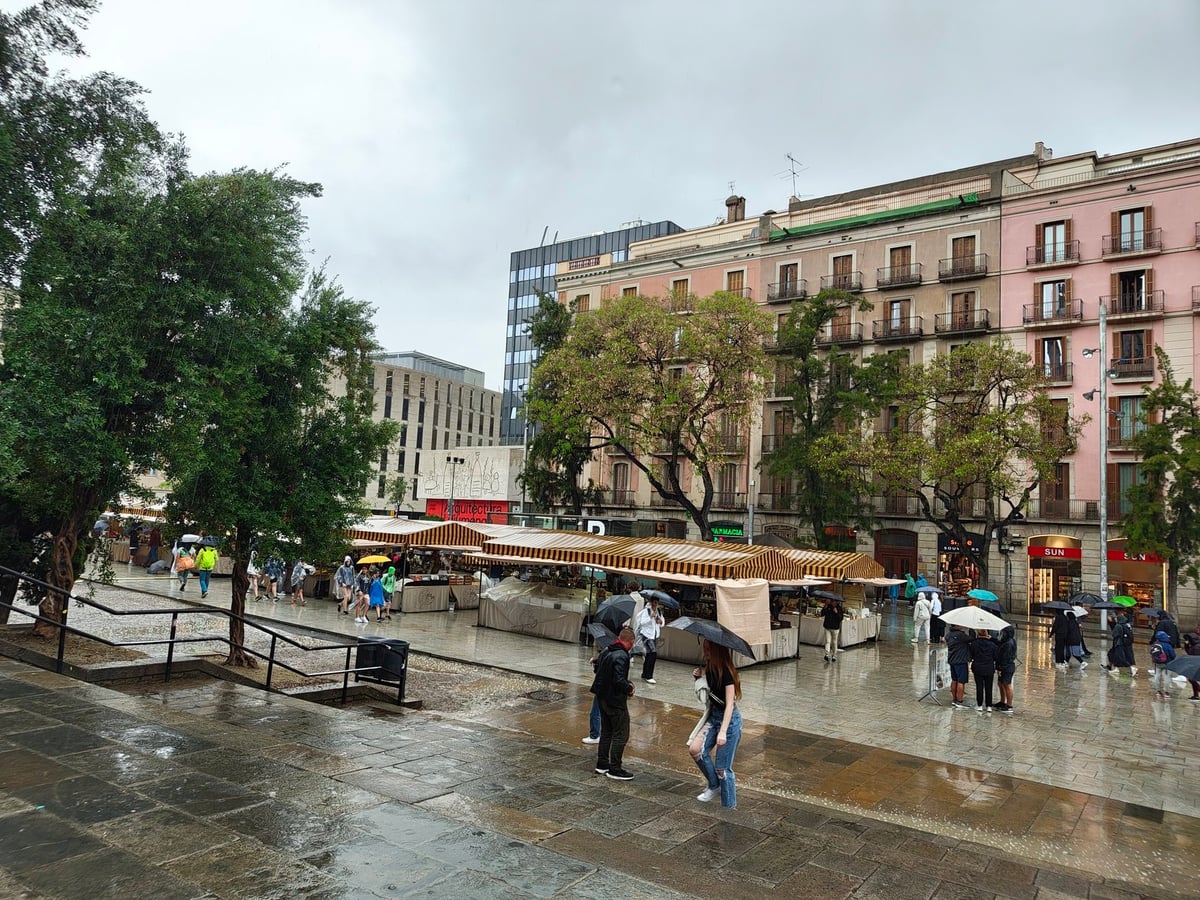 Plaza de Barcelona bajo la lluvia con edificios históricos