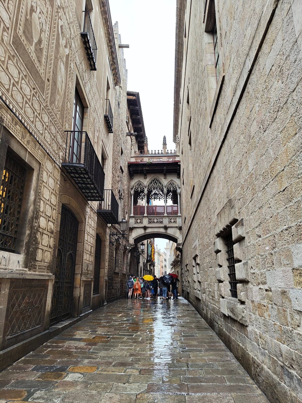 Calle estrecha de piedra del Barrio Gótico bajo la lluvia