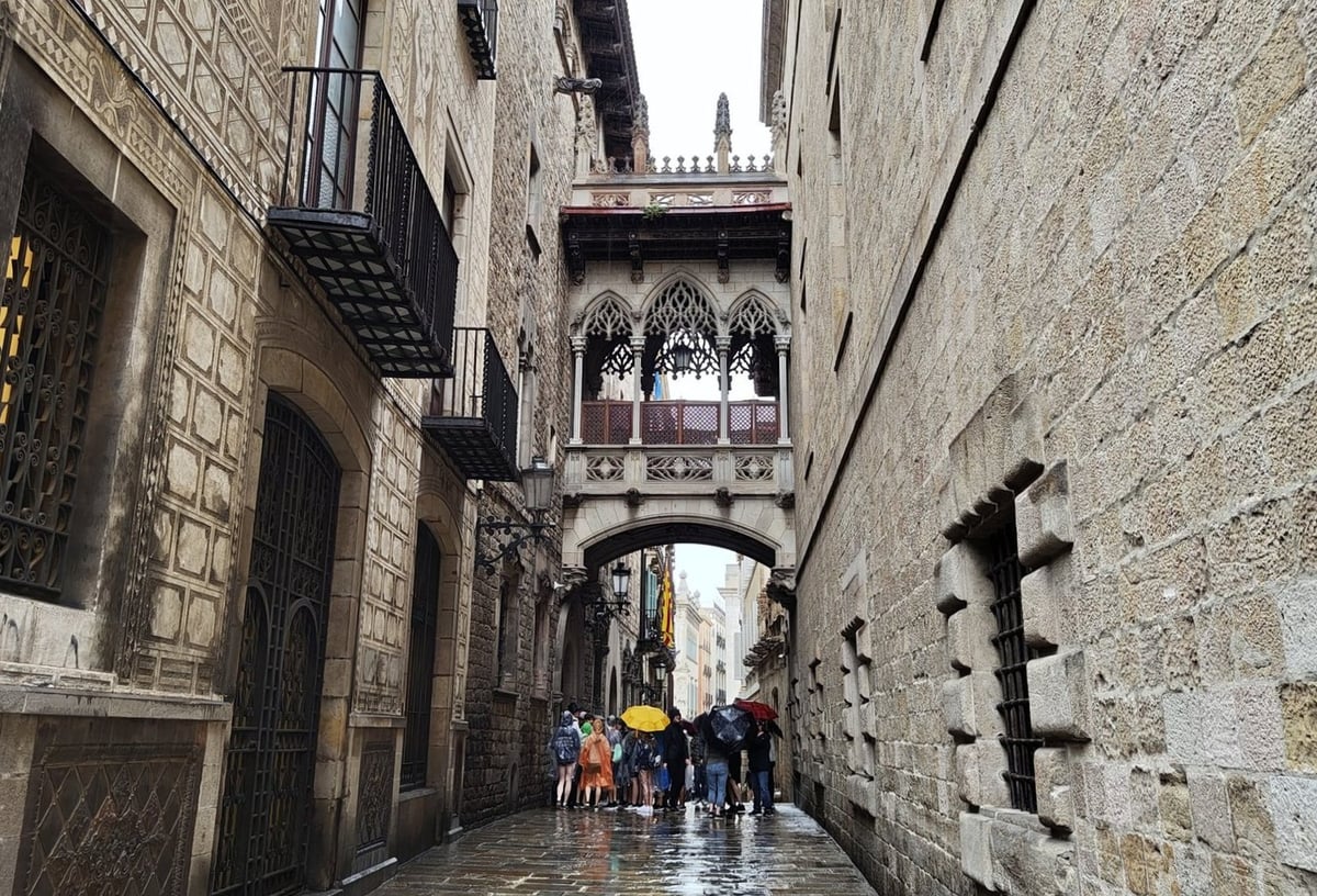 Calle del Barrio Gótico con un puente elevado entre edificios