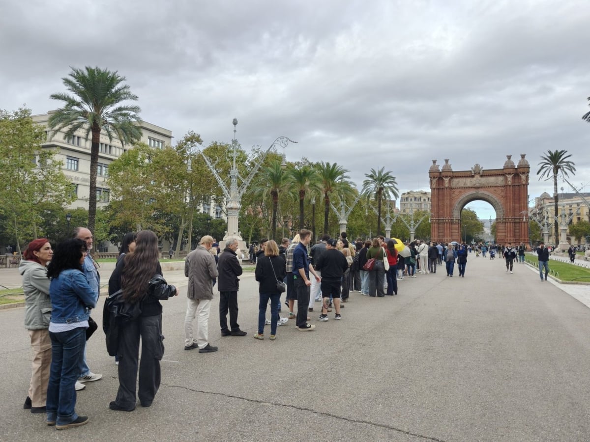 El Arco de Triunfo de Barcelona visto desde el Passeig de Lluís Companys, con gente paseando y haciendo cola en la avenida