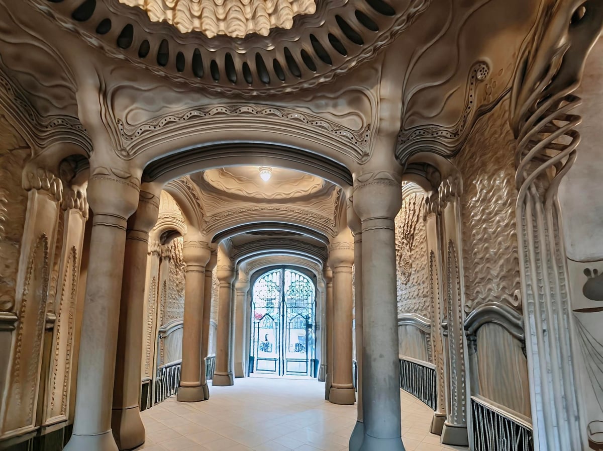 Pasillo monumental con columnas y decoración escultórica
