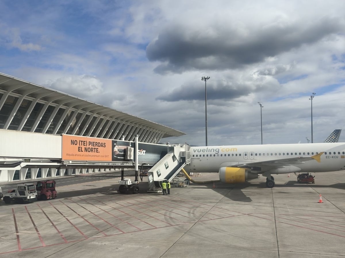 Avión estacionado en la pista de un aeropuerto bajo un cielo nublado