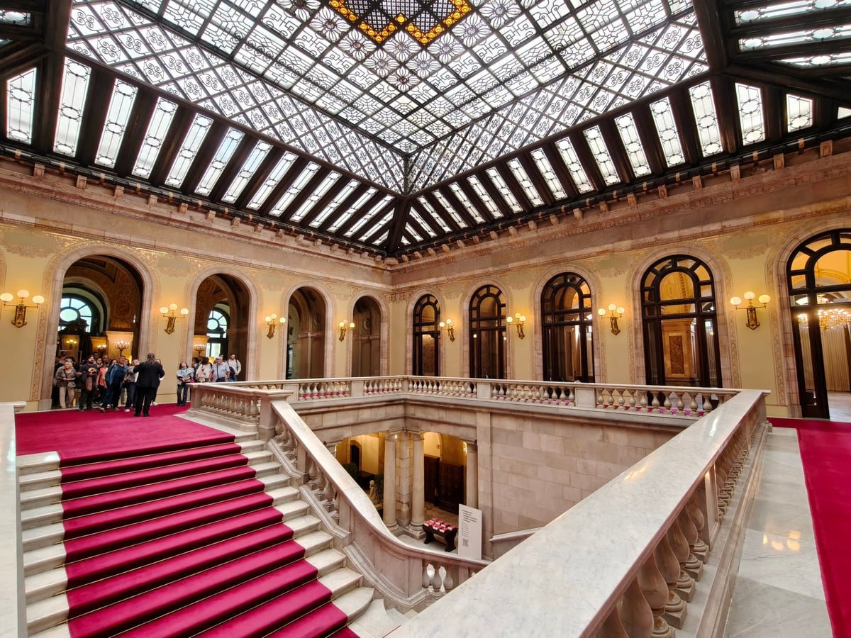 Fachada principal del Parlament de Catalunya, con sus arcadas de piedra y el escudo catalán, entre los jardines del Parc de la Ciutadella