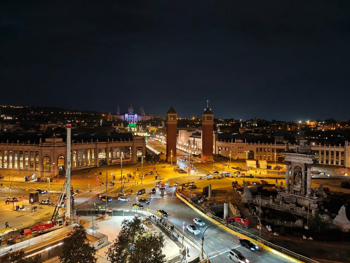 Vista nocturna de la plaza de España desde la terraza de Las Arenas, con las dos torres venecianas, la avenida iluminada y Montjuïc al fondo.