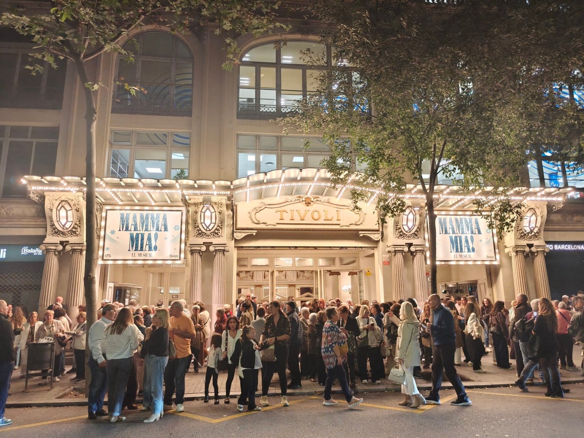 Fachada del Teatre Tívoli de noche, con los carteles de Mamma Mia! en la marquesina y una multitud esperando en la acera.