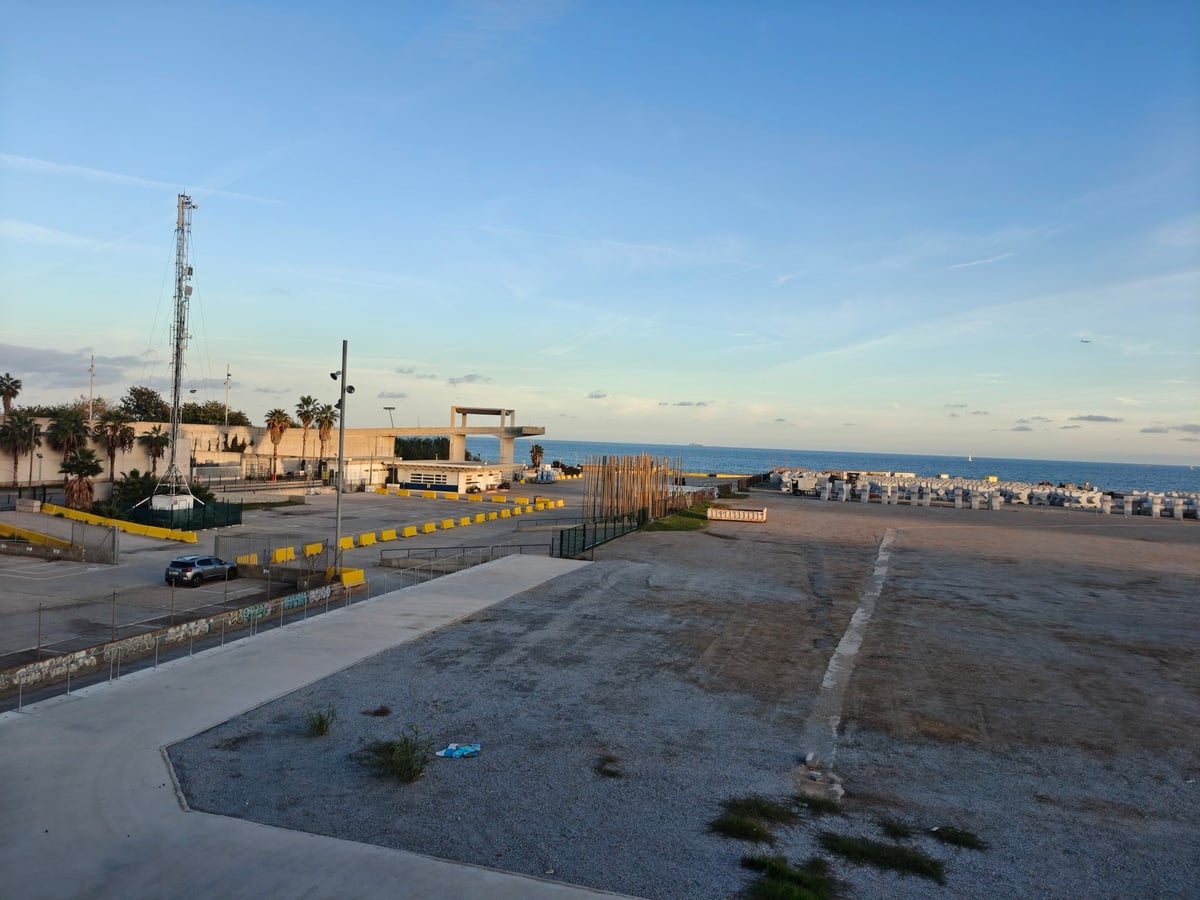 Explanada junto al mar en la zona del Fórum, con casetas de playa y el Mediterráneo al fondo, al atardecer.