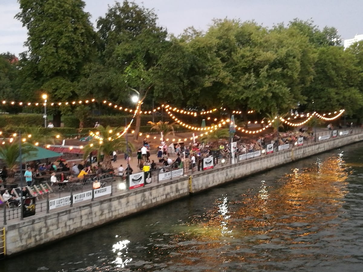 Canal de Berlín iluminado por la noche con terrazas junto al agua