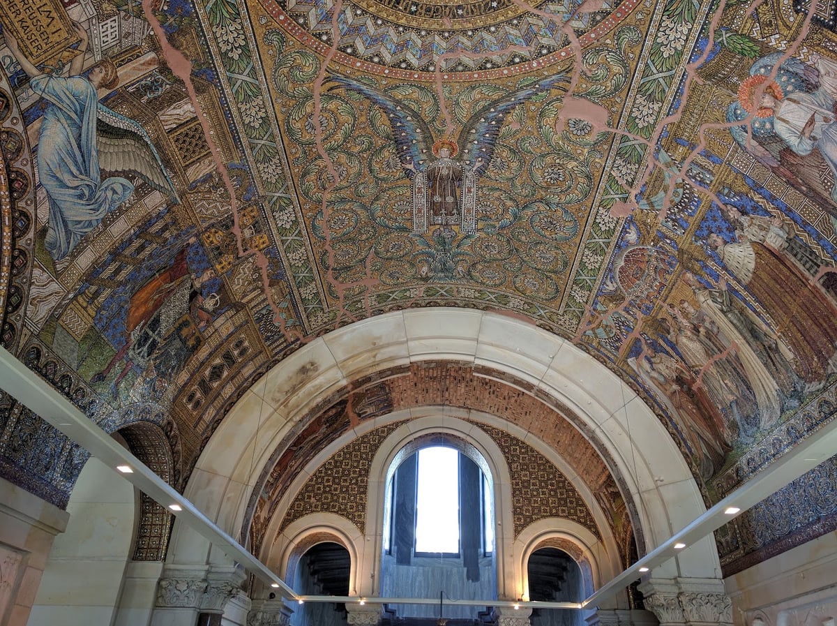 Interior de un edificio monumental con decoración en la cúpula