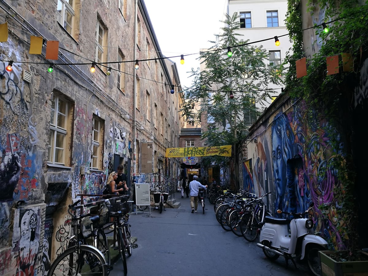 Calle estrecha de Berlín con bicicletas y murales