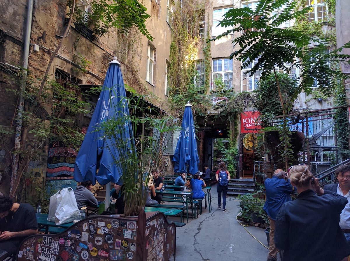 Terraza exterior con mesas rodeadas de grafitis