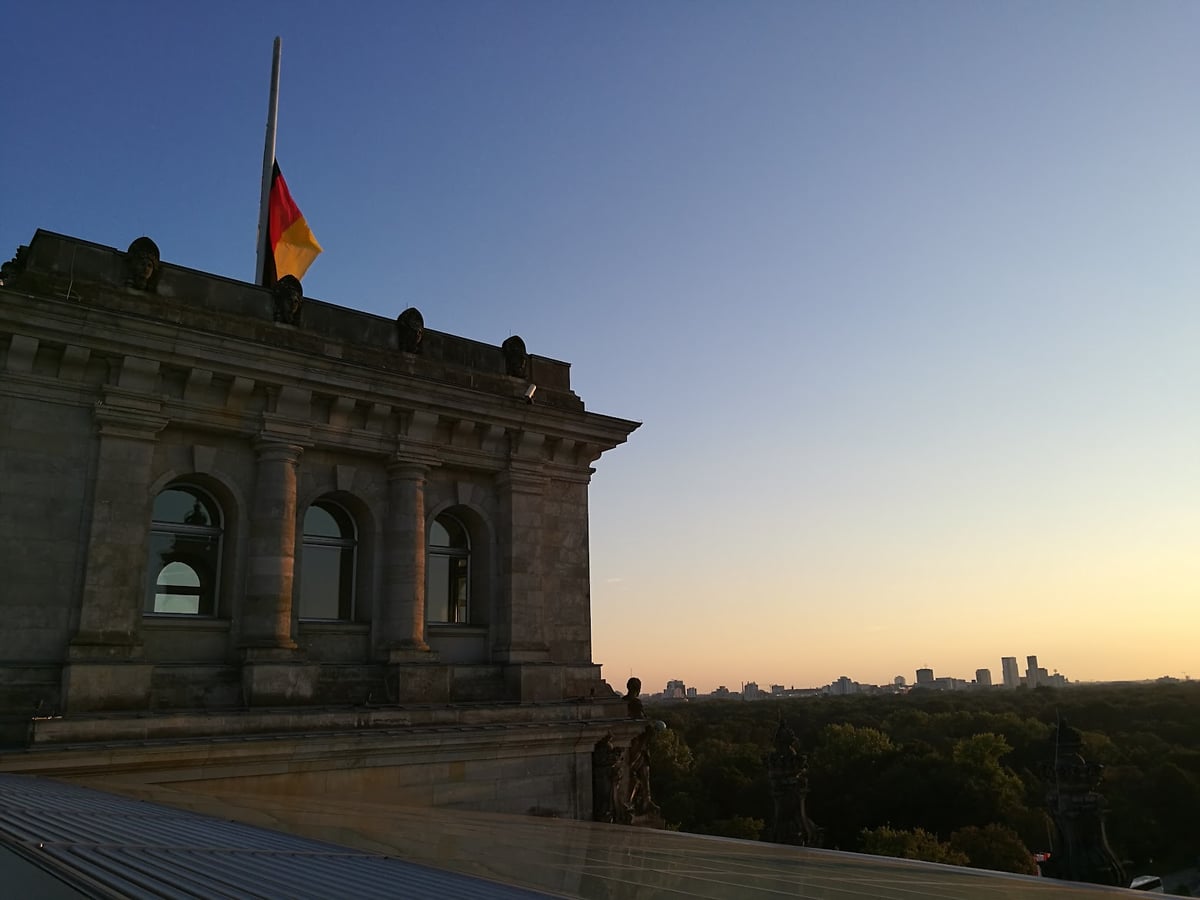 Edificio histórico con la bandera alemana al atardecer
