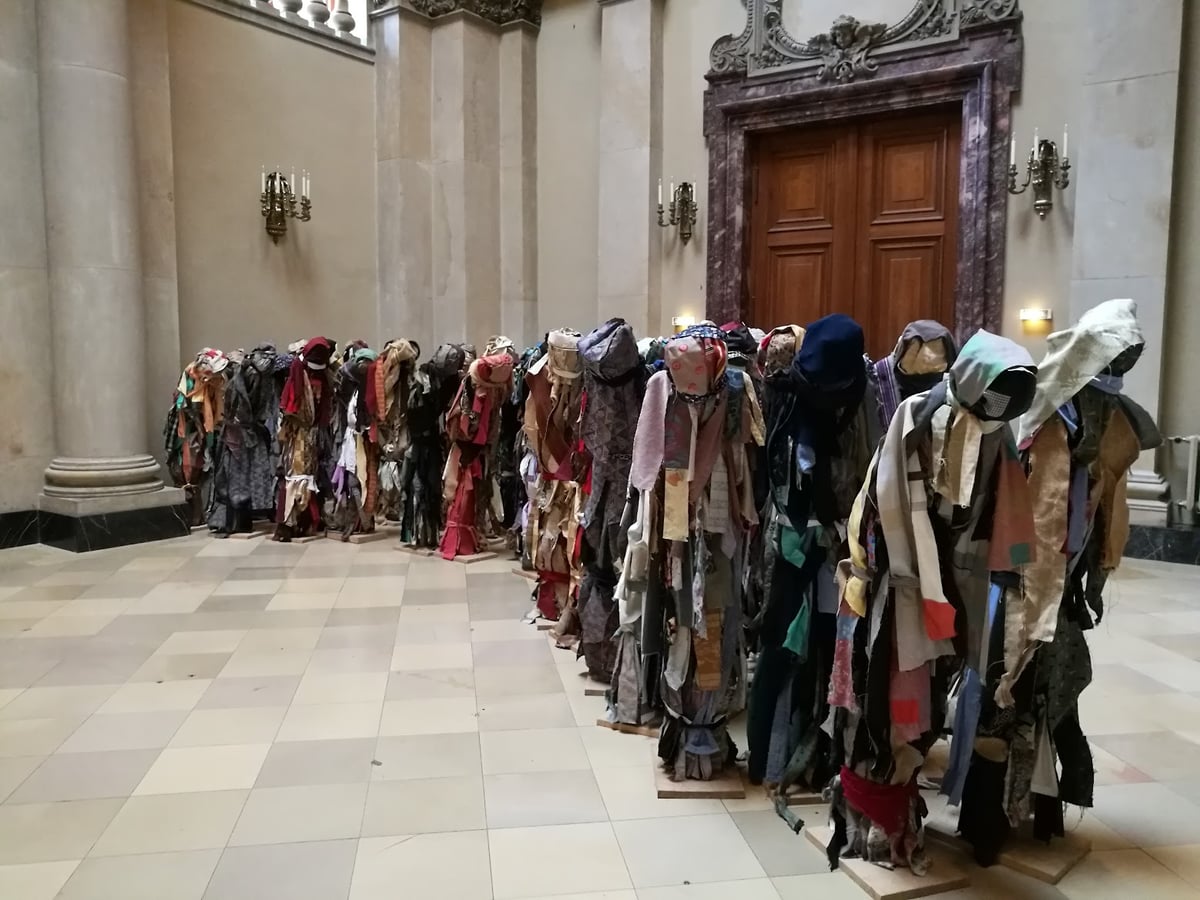 Fila de esculturas o vestimentas expuestas en una sala