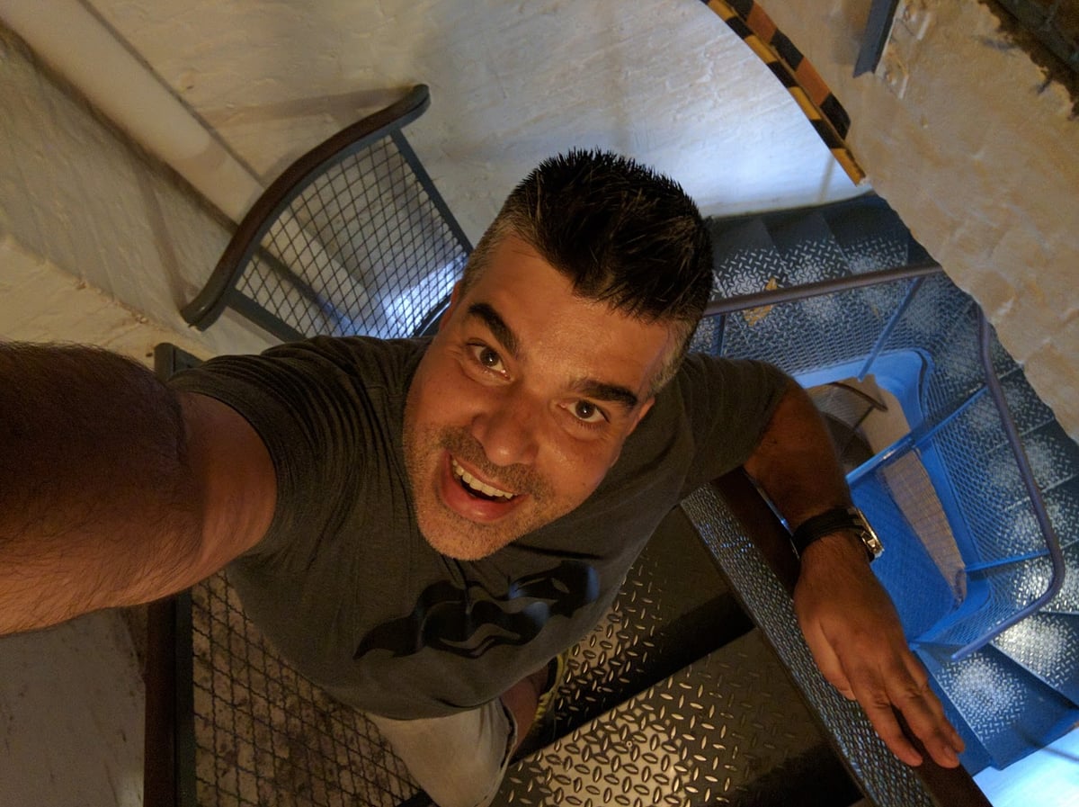 Persona fotografiándose en una escalera interior
