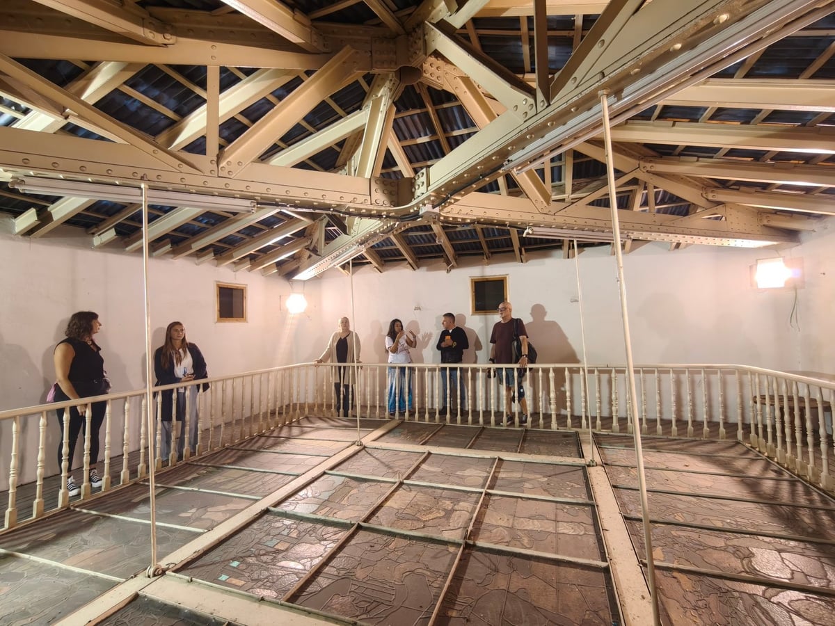 Grupo de voluntarios visitando el desván del Palacio Ibaigane, con la estructura que sostiene la gran vidriera del patio