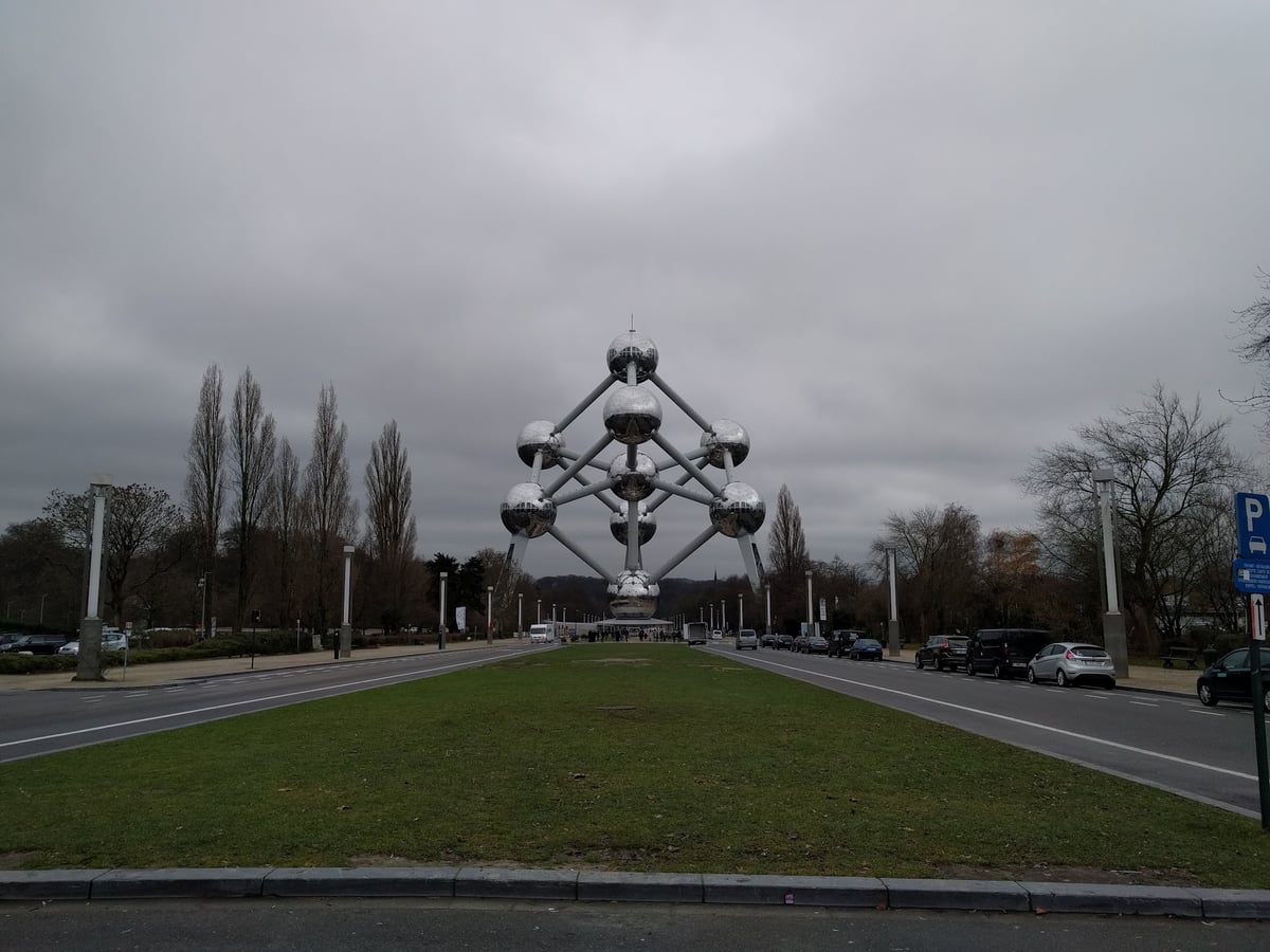 El Atomium de Bruselas visto de frente entre árboles pelados de invierno