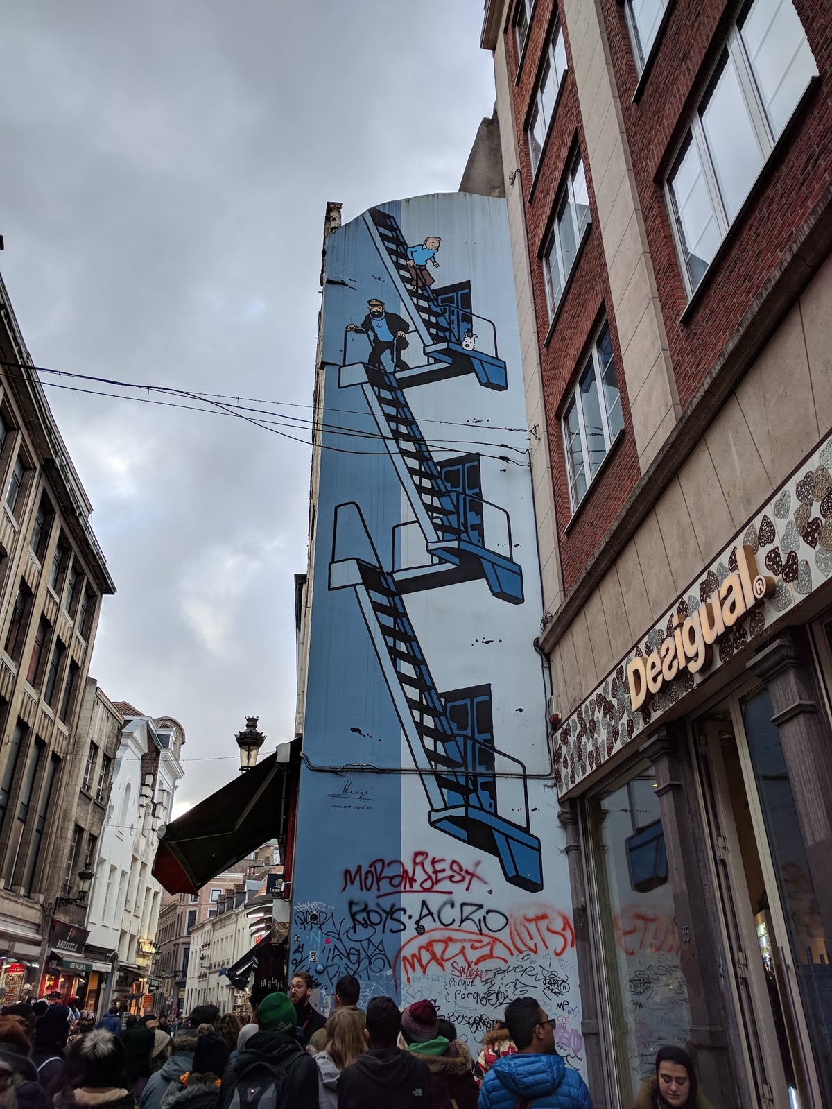 Detalle de un mural de cómic pintado sobre una fachada de ladrillo en Bruselas