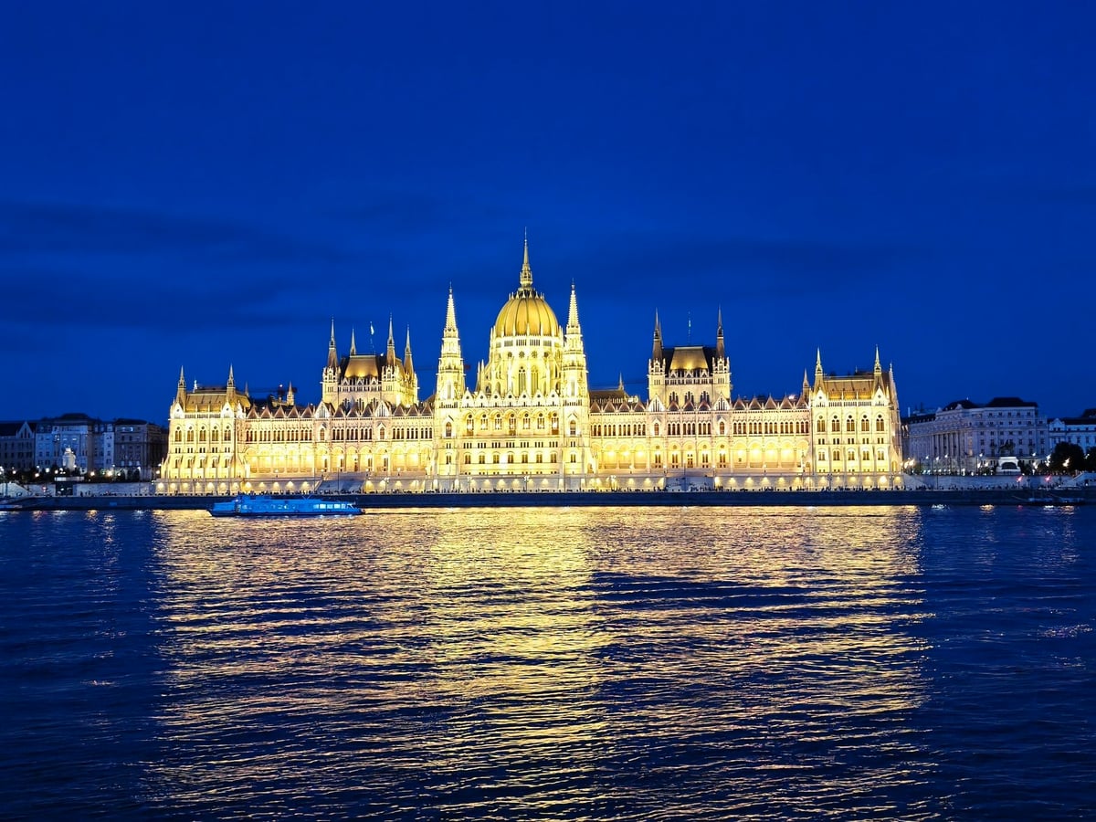 El Danubio de noche en Budapest, con las orillas de Buda y Pest iluminadas a ambos lados