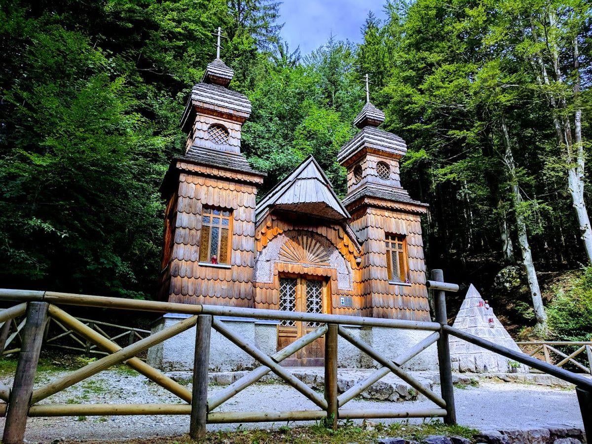La carretera del paso Vršič a la altura de la curva 8, con firme adoquinado ascendiendo entre bosque de coníferas.