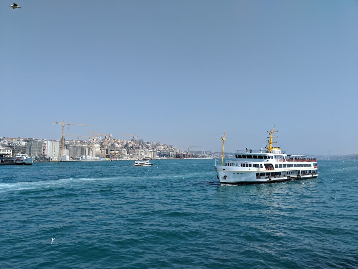 Ferri cruzando el Bósforo desde Eminönü, con la cubierta exterior llena de pasajeros y la silueta de la ciudad histórica al fondo.
