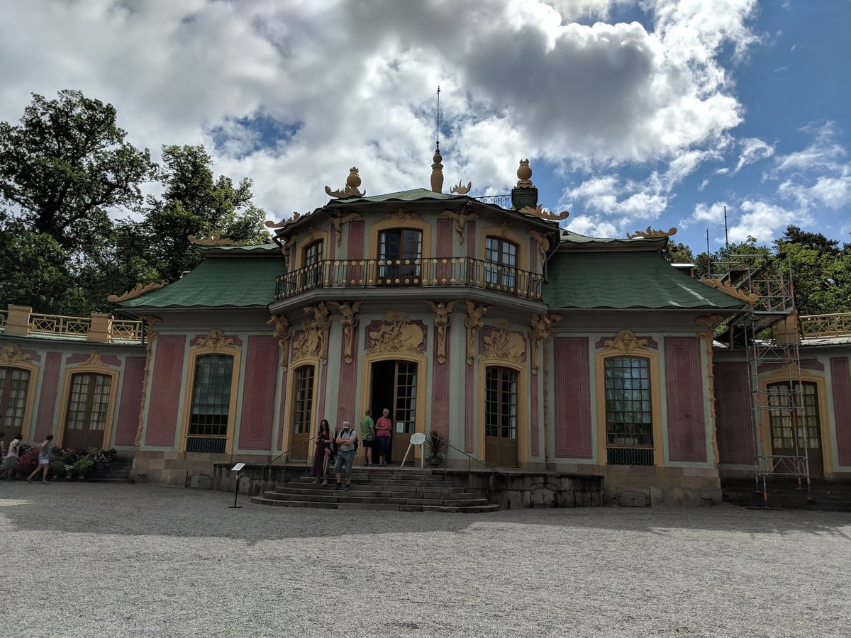 El Kina Slott, el pabellón chino de Drottningholm, con su tejado verde y su fachada rosa entre los jardines