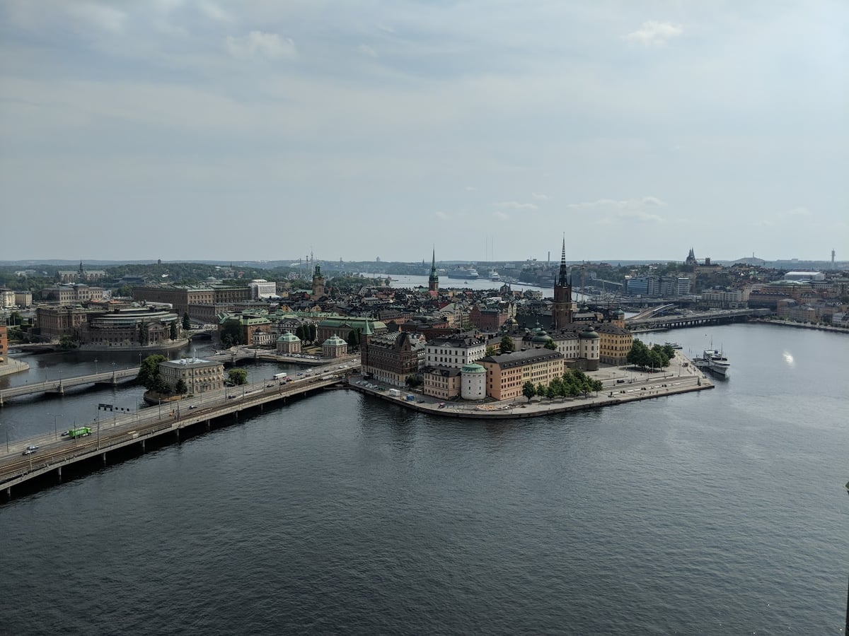 Estocolmo desde lo alto, con la isla de Riddarholmen y su iglesia de aguja calada en el centro, rodeada de agua, los puentes que la unen a la ciudad y el casco antiguo extendiéndose al fondo.