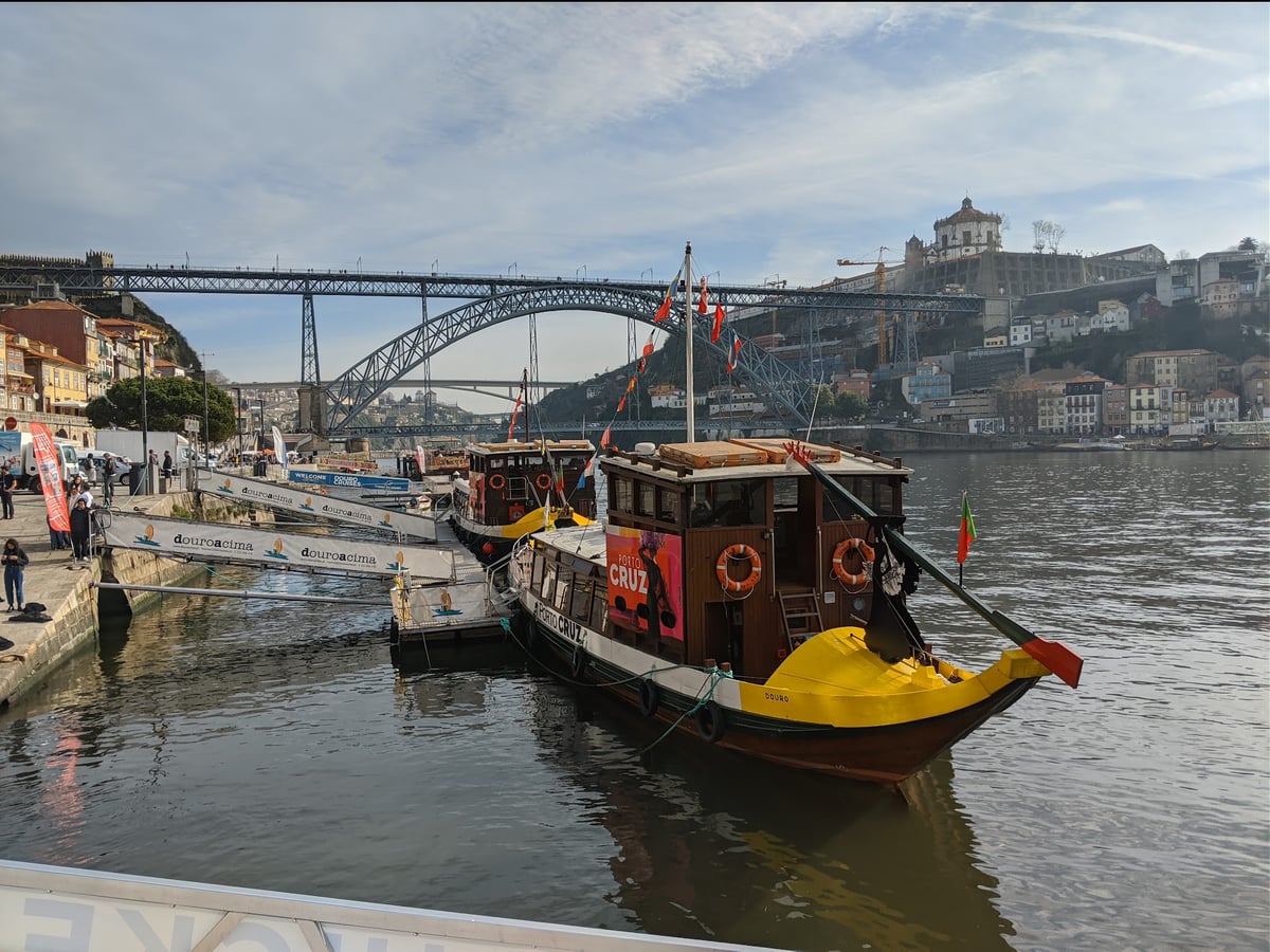 Barco rabelo tradicional en el río Duero, con el icónico Puente Don Luis I al fondo en Oporto, Portugal.