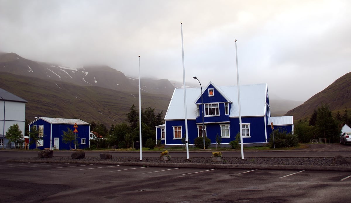 El fiordo de Seyðisfjörður visto desde el puerto de montaña, con el pueblo y el agua quieta al fondo del valle.