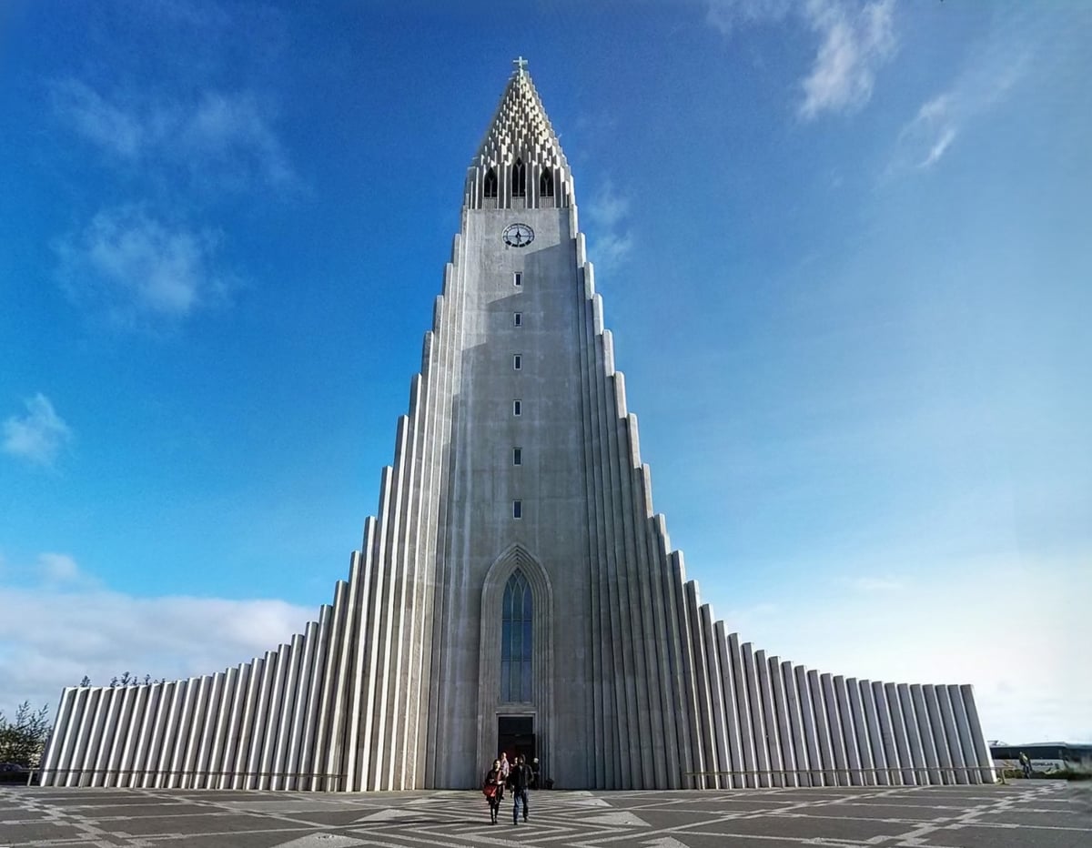 La Hallgrímskirkja de Reikiavik vista desde la calle, con su fachada de hormigón en columnas de basalto y la estatua de Leif Erikson delante.