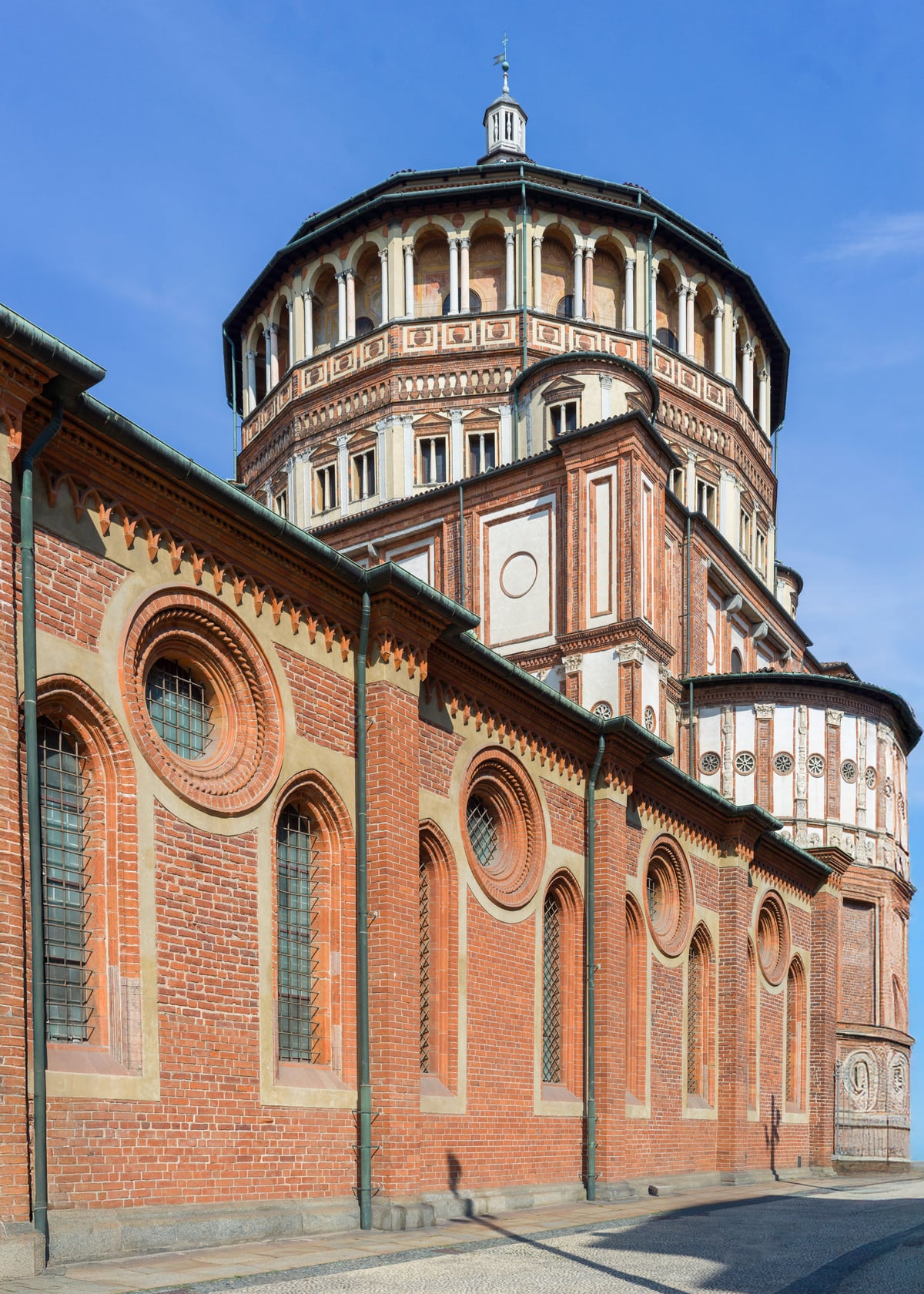 Vista de la arquitectura de ladrillo rojo de Santa Maria delle Grazie contra un cielo despejado.