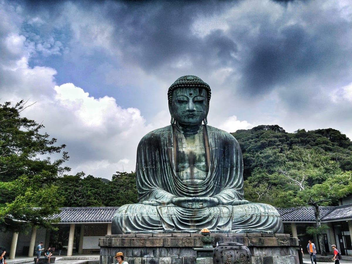 El Gran Buda de Kamakura, la estatua de bronce al aire libre del Kōtoku-in, con los peregrinos a sus pies.