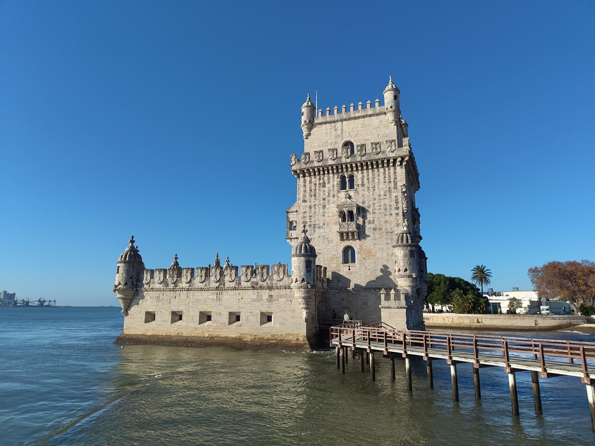 La Torre de Belém a orillas del Tajo, con su bastión circular y sus torrecillas manuelinas recortadas contra el cielo y el agua del estuario.