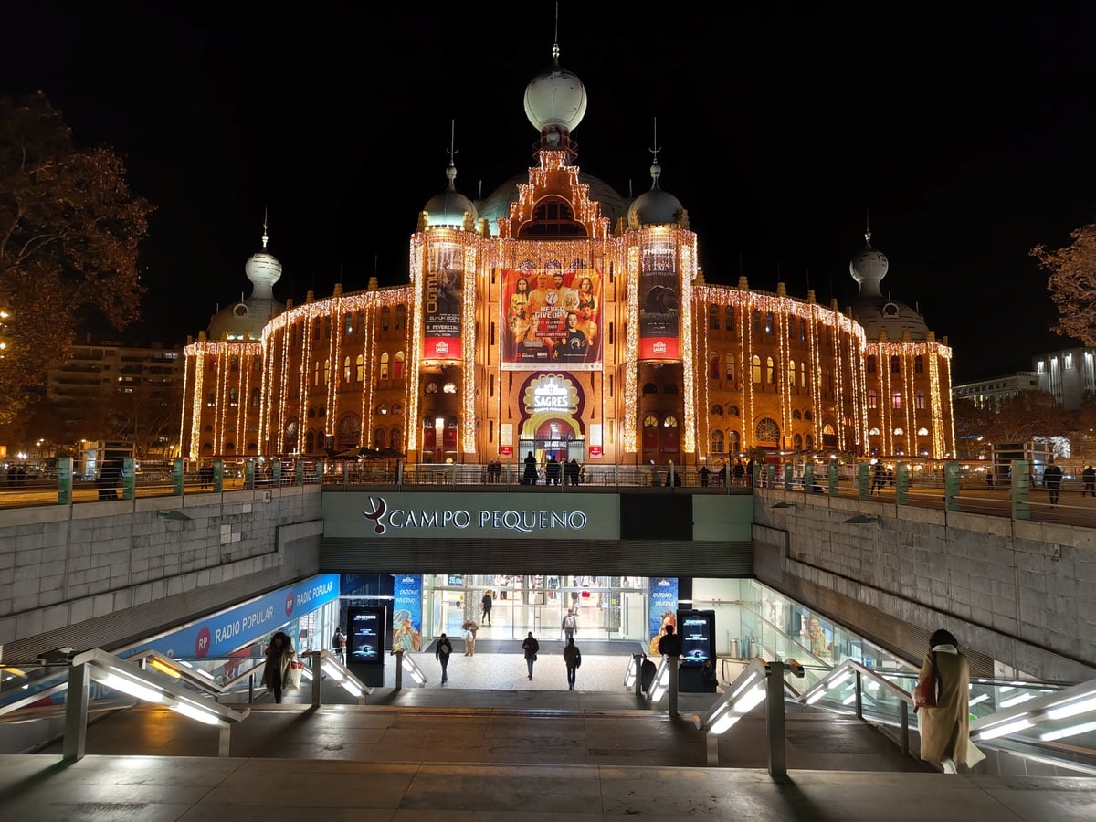 La noria y las luces de la feria navideña de Wonderland Lisboa, en la rotonda de Marqués de Pombal, con el cielo ya oscurecido.