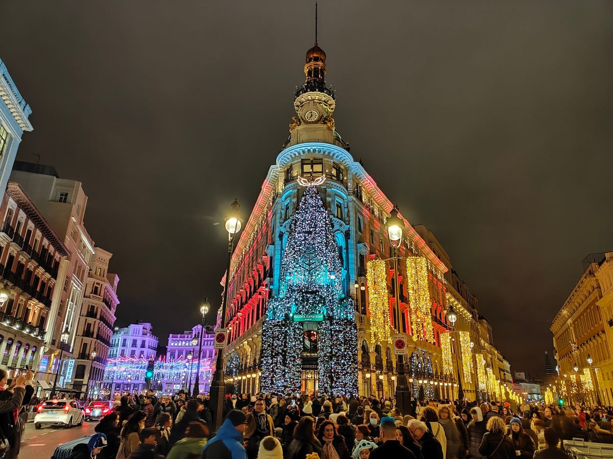 La Puerta del Sol de Madrid engalanada con las luces de Navidad y llena de gente.