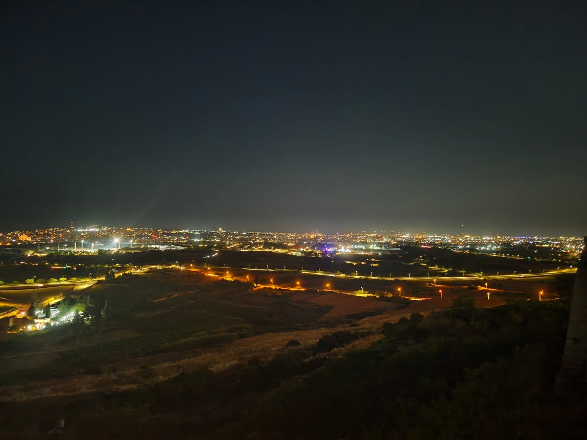 Un callejón silencioso de Mdina de noche, sin un alma, entre fachadas de piedra dorada.